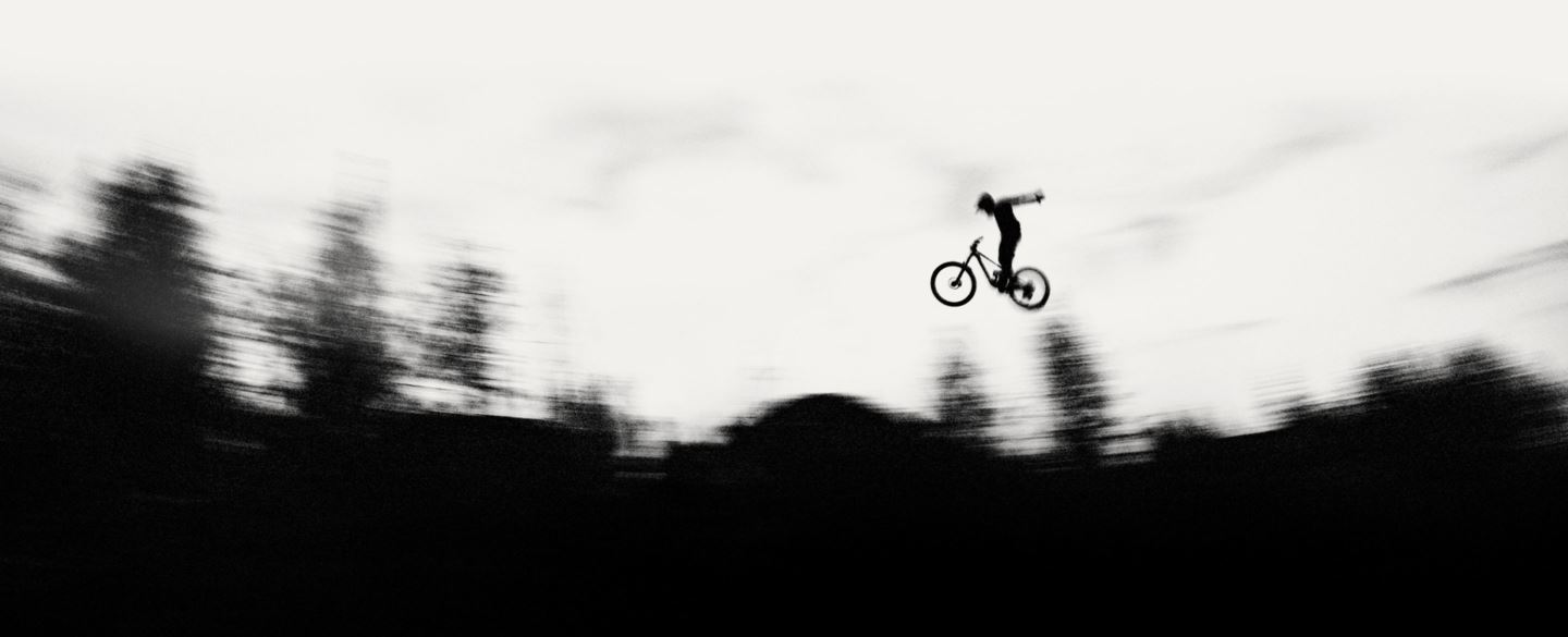 Black and white image of MTB rider silhouetted against sky