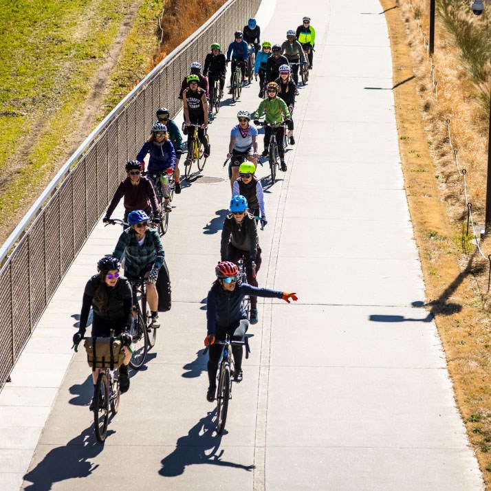 Group of cyclists riding on a paved bike trail