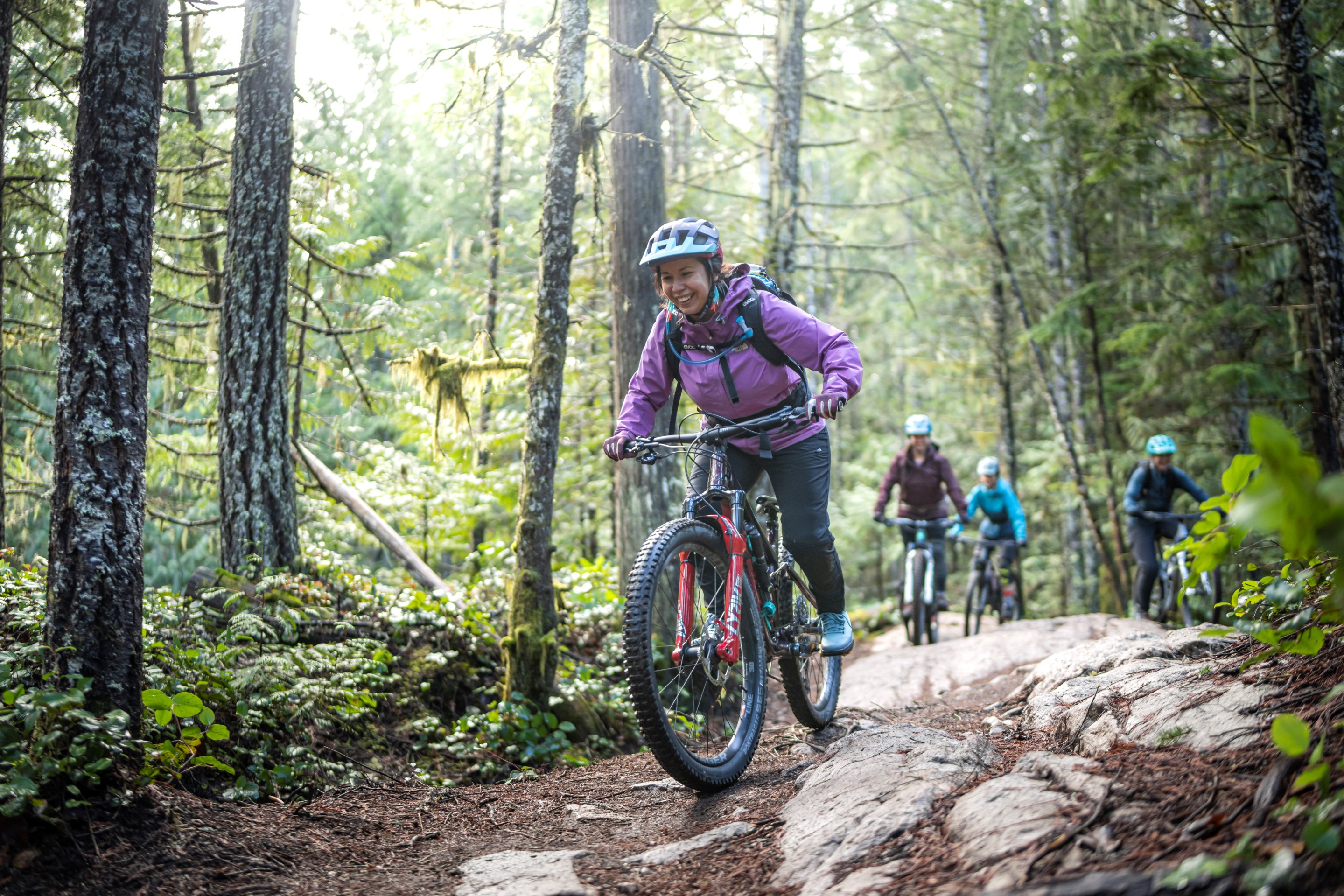 Michele Lobo riding and smiling in the woods