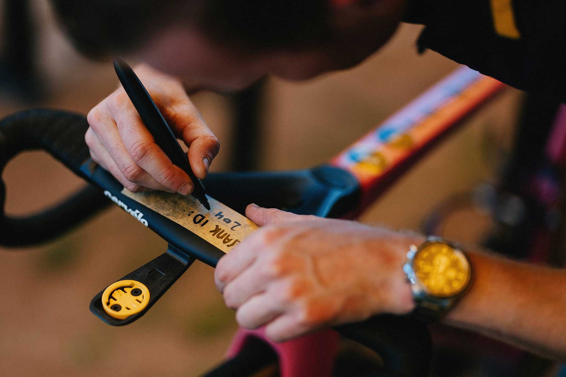 A mechanic puts the finishing touches on Roglic's pink bike