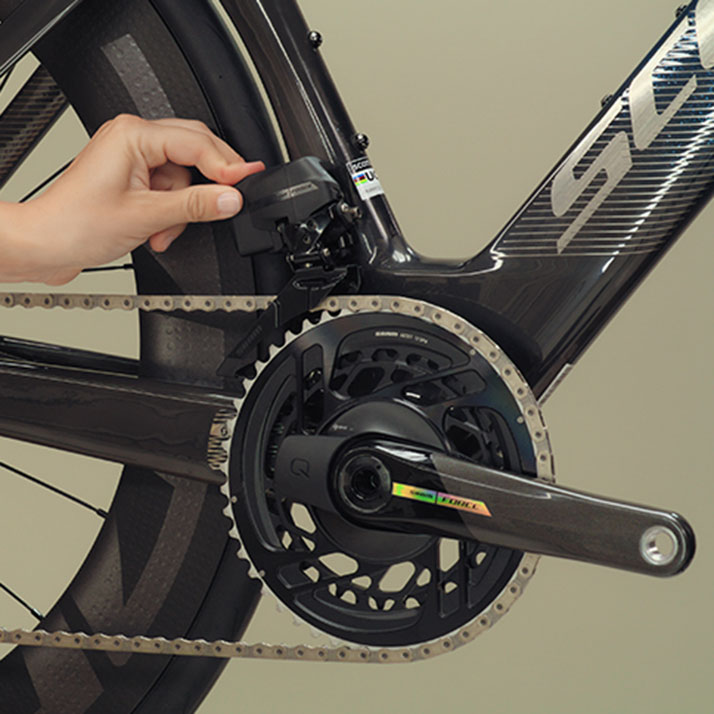 A rider installs a battery onto a SRAM Force AXS front derailleur